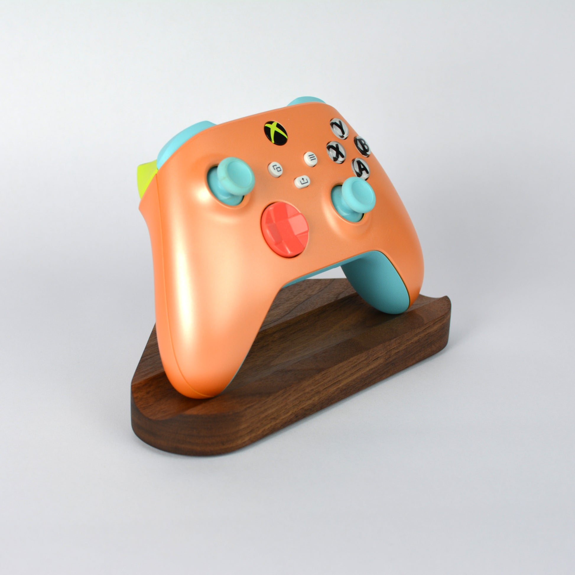 Colorful gaming controller on a wooden stand against a white background