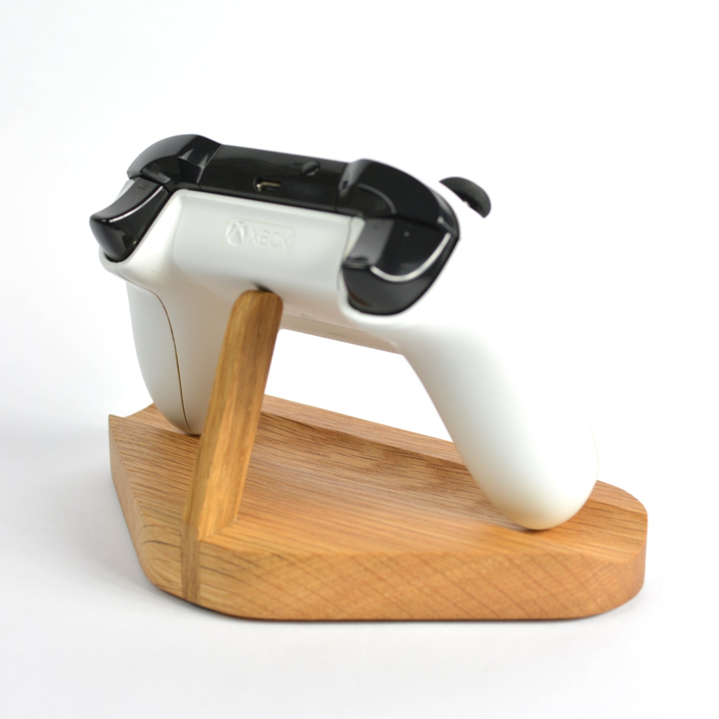 White and black electronic device on a wooden stand against a white background