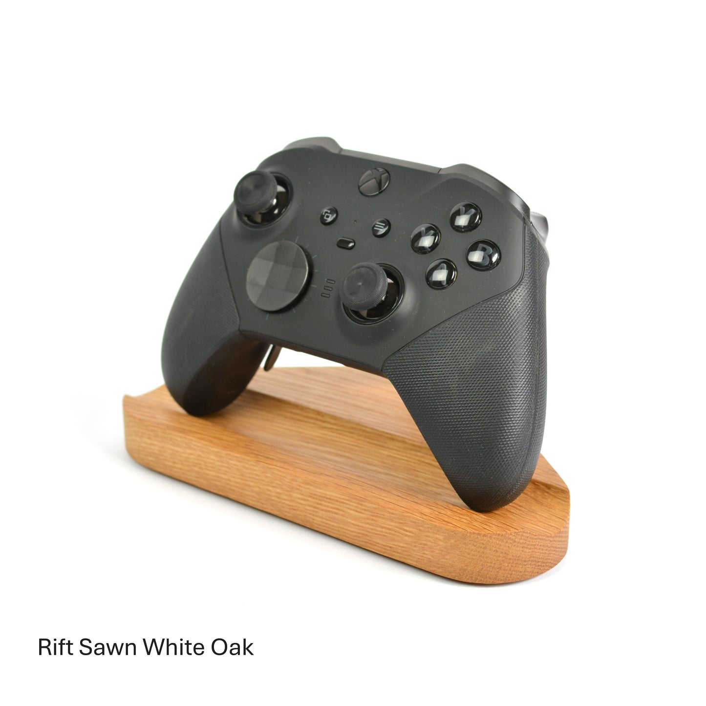 Black gaming controller on a wooden stand with 'Rift Sawn White Oak' text below.