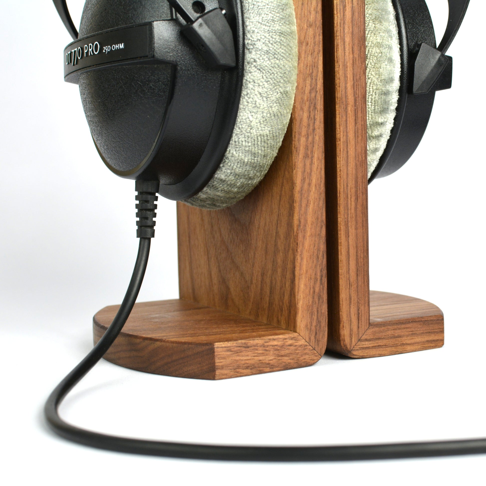 Headphones on a wooden stand with a white background