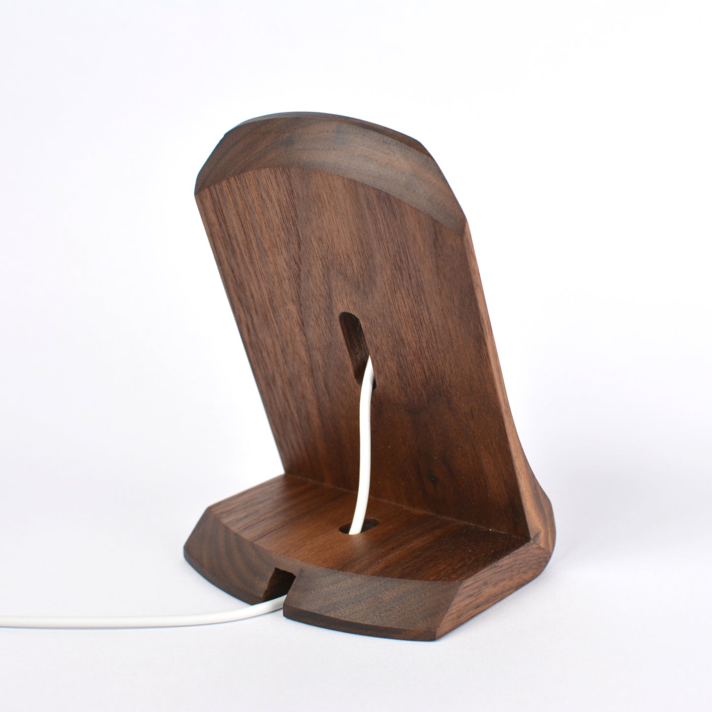 Wooden phone stand with a white cable on a white background
