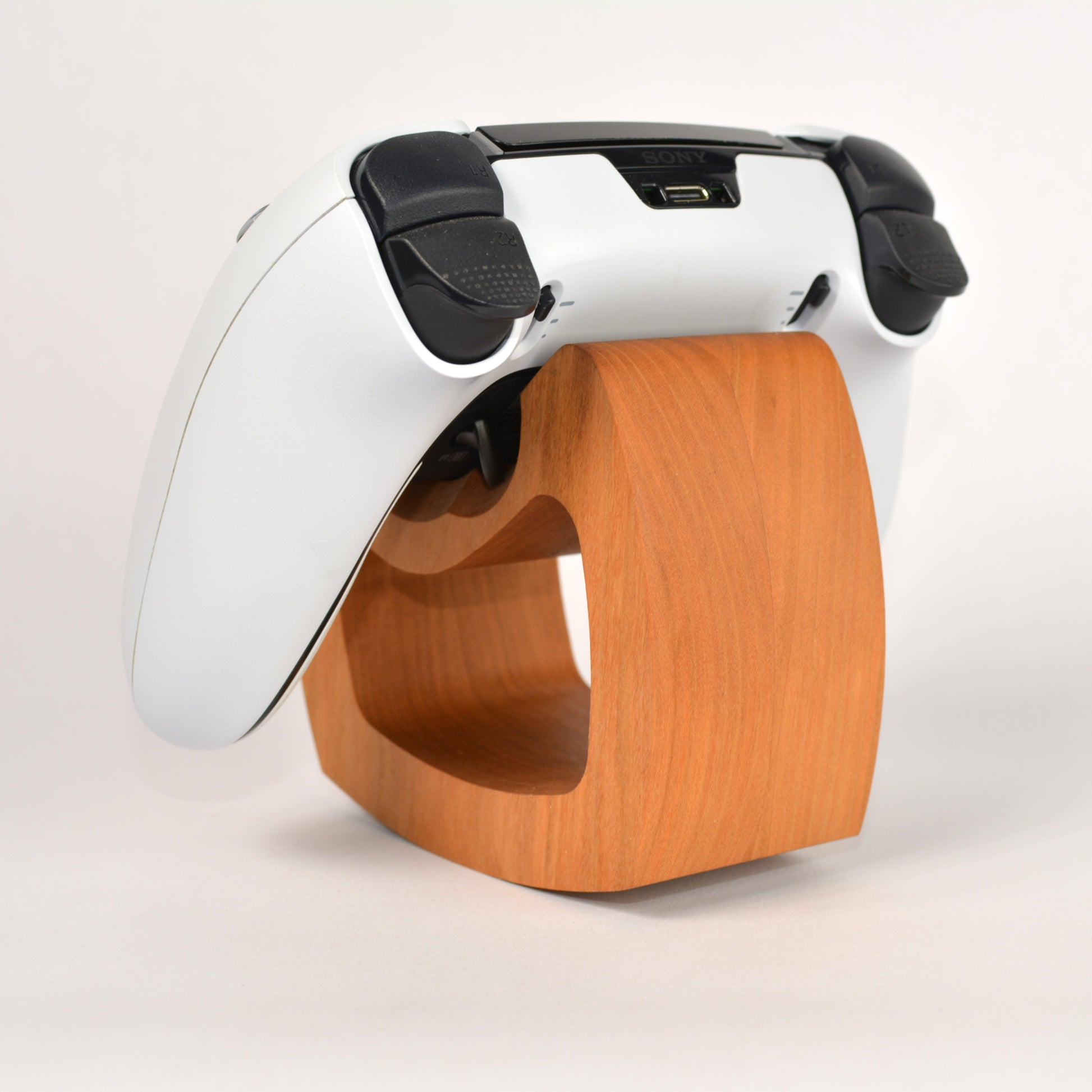 White and black device with a wooden base on a light background