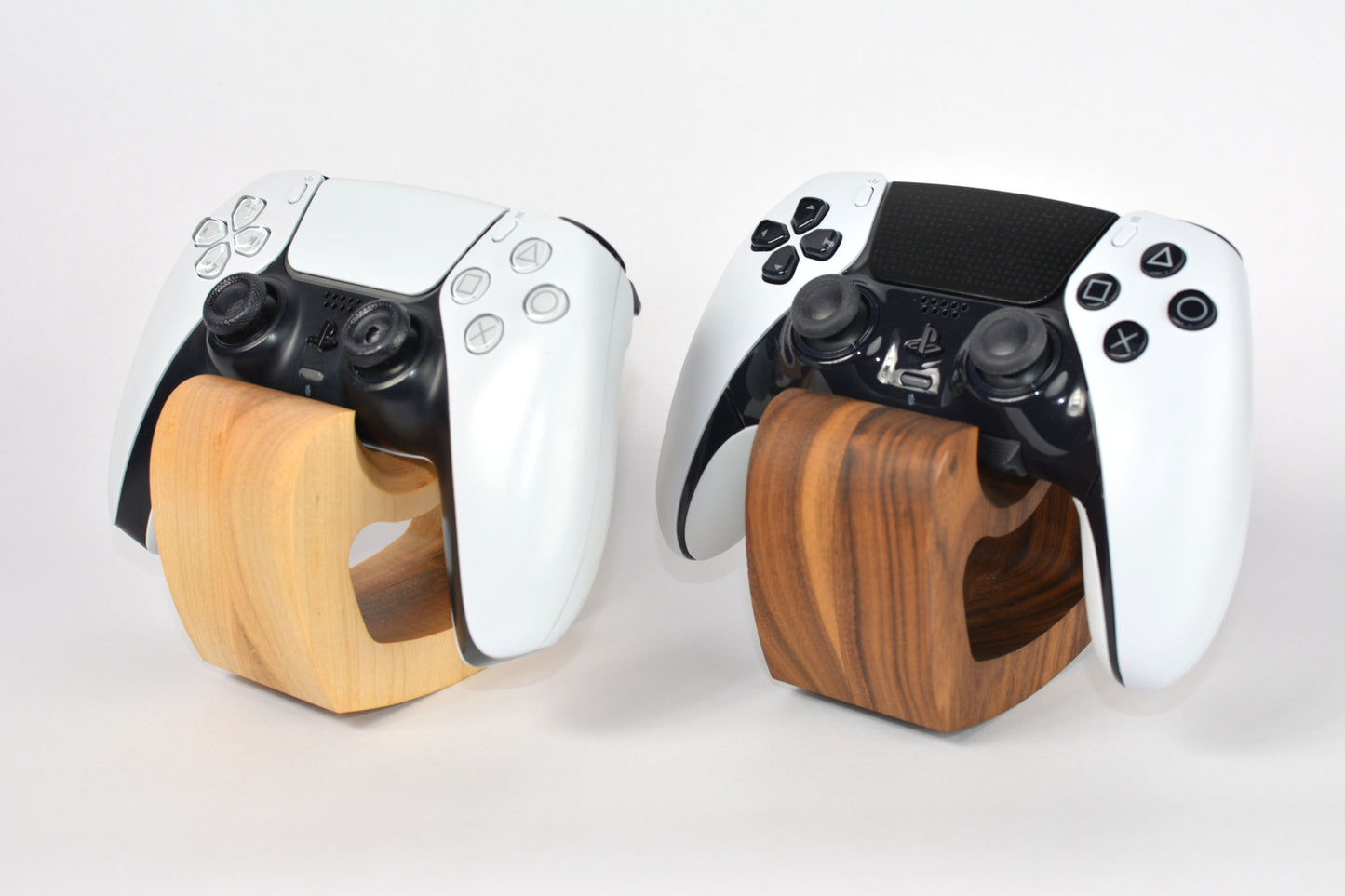 Two gaming controllers with wooden bases on a white background