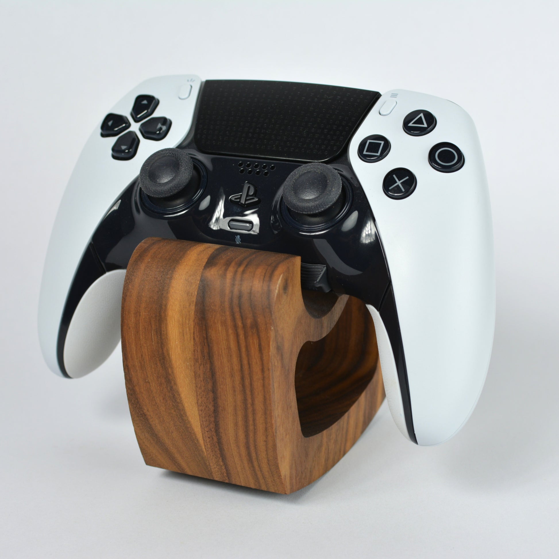 Gaming controller on a wooden stand against a white background