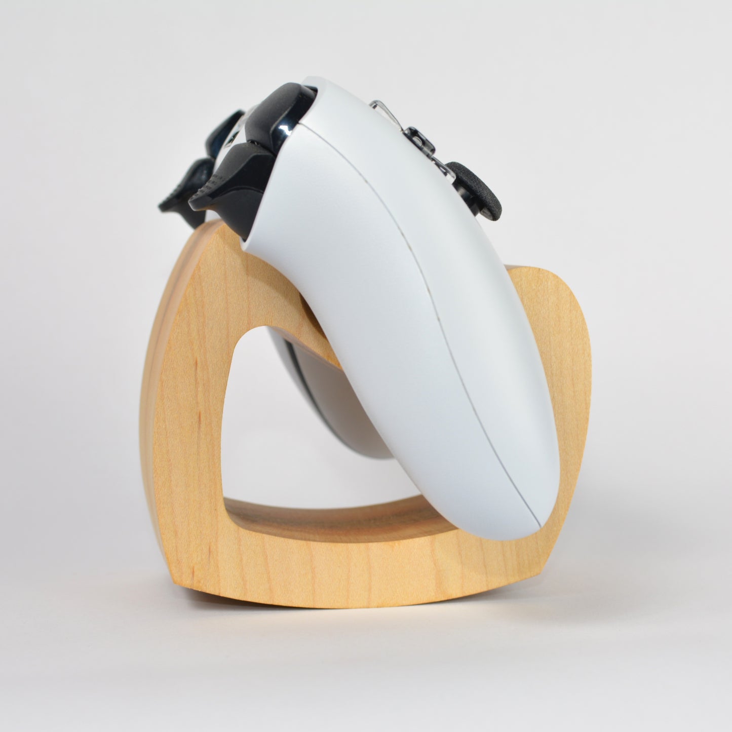 White electronic device with black components on a wooden stand against a white background