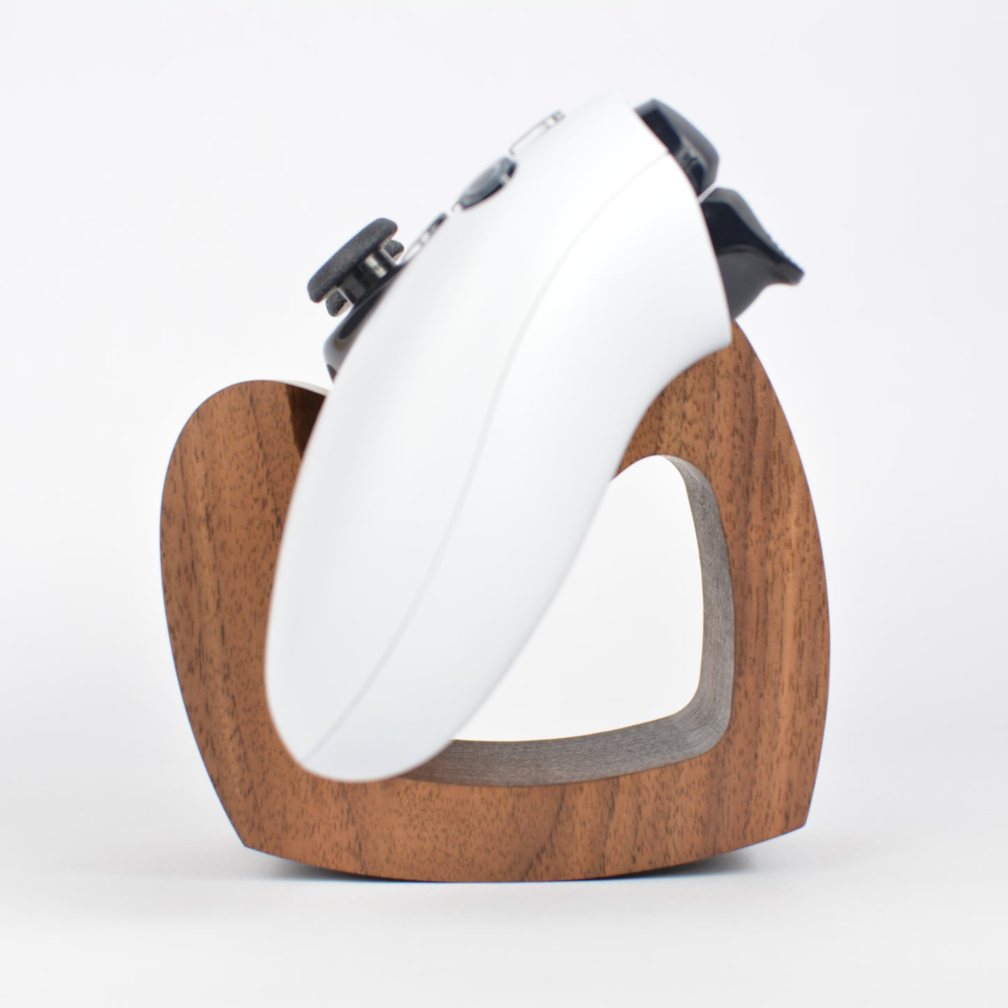 White electronic device on a wooden stand against a white background