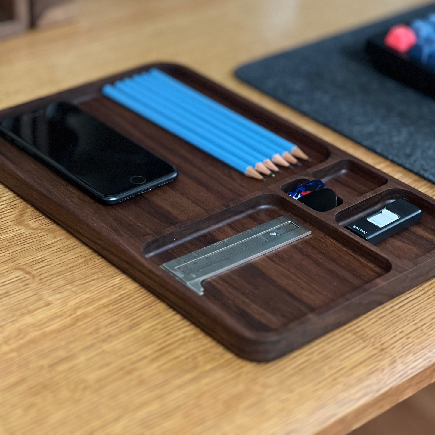 Wooden desk organizer with phone, pencils, and other items on a wooden surface