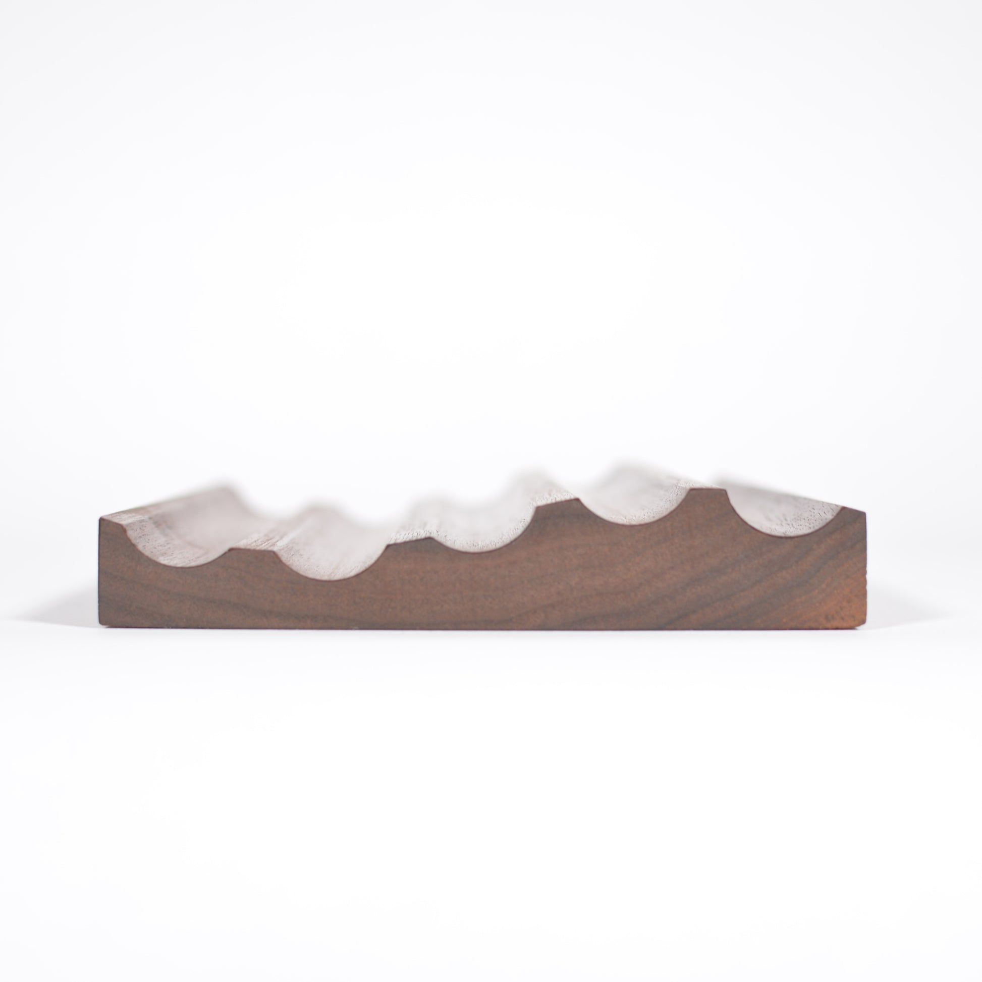 walnut fountain pen tray with a wavy, scalloped white ceramic or stone rim, photographed against a seamless white background.